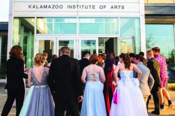 A group of people, dressed for a prom, prepares to enter the KIA.